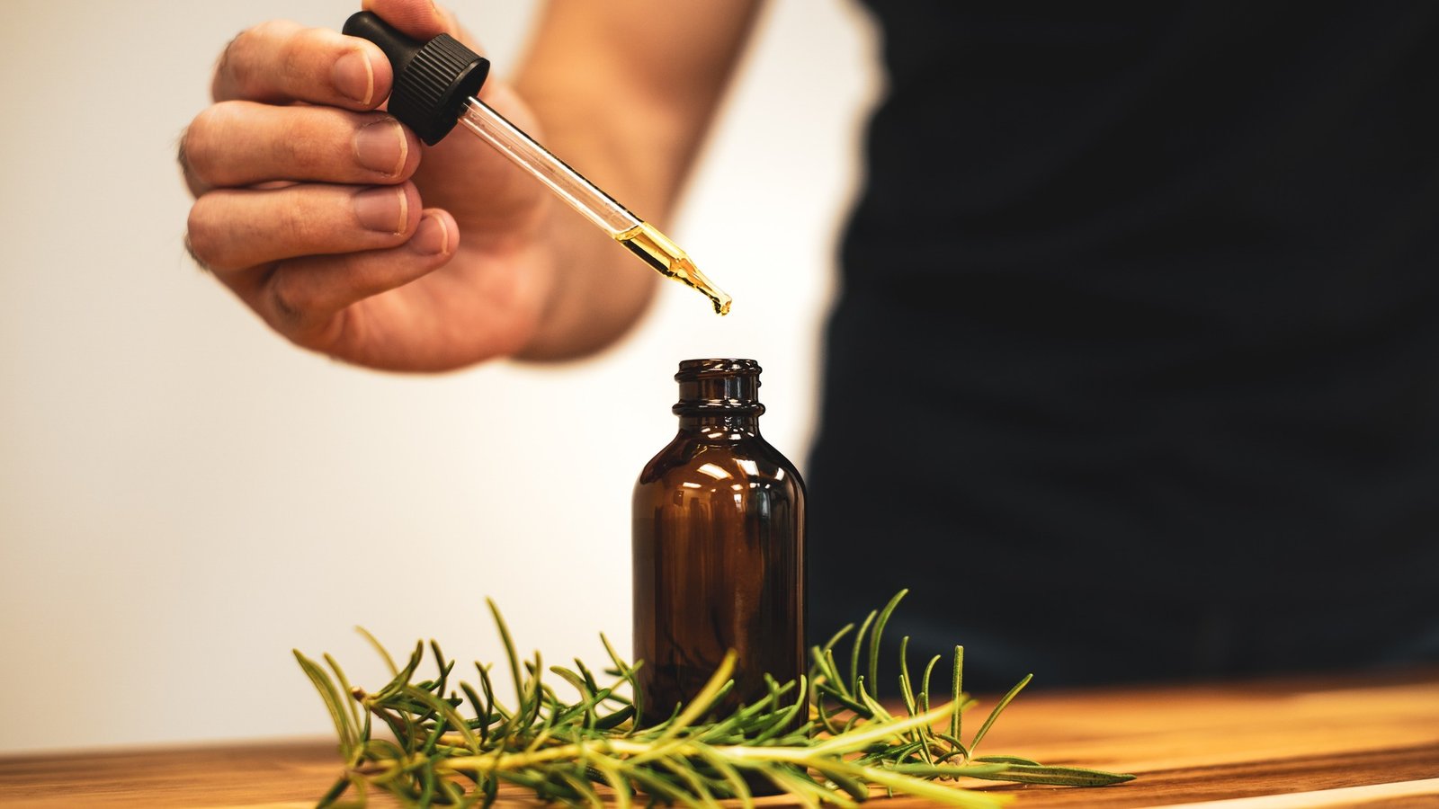 Amber dropper bottle applying pure botanical ginseng scalp serum for hair follicle density